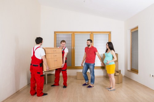 Professional movers loading items into a van on a London street